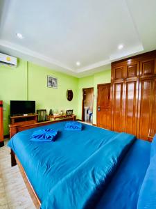 卡塔海灘的住宿－BT hotel Kata Beach，一张蓝色的大床,位于带绿色墙壁的房间
