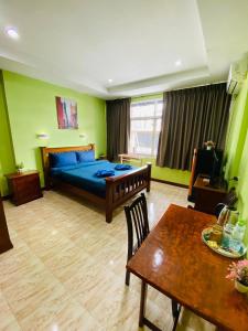 a bedroom with a blue bed and a table and a table sidx sidx at BT hotel Kata Beach in Kata Beach