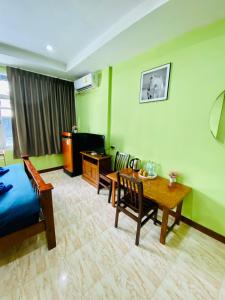 Cette chambre comprend un lit, une table et des chaises. dans l'établissement BT hotel Kata Beach, à Kata Beach