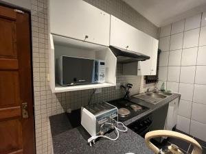 a small kitchen with a stove and a microwave at Kiwi Boutique Lodges in Pretoria