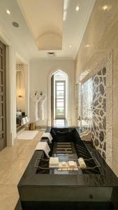 a large bathroom with a black tub in a room at Raffles Al Areen Palace Bahrain in Manama