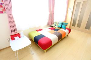 sypialnia z kolorowym łóżkiem i białym krzesłem w obiekcie Sun River Annex Inaho - Vacation STAY 95961 w mieście Kita-hamachō