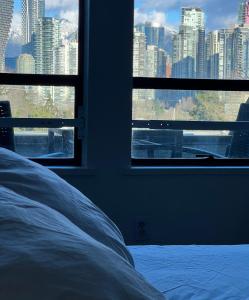 a bedroom with a view of a city from a window at Charming Heritage Home with Mountain and City Views in Vancouver