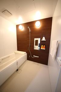 W łazience znajduje się wanna i prysznic. w obiekcie Sun River Annex Inaho - Vacation STAY 95961 w mieście Kita-hamachō