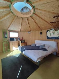 een slaapkamer met een bed in een kamer met een plafond bij Auberge du Col du Festre in Le Dévoluy