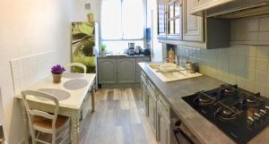 a kitchen with a table and a stove top oven at NATURALBNB - Chambres d'hôtes bios, éthiques - Au calme, confort dans résidence fermée - PARKING GRATUIT, SECURISE - Garage vélos et motos - OFFERT SUPER PETIT DEJEUNER local et bio sucré salé in Villeurbanne