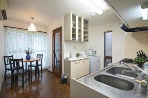 a kitchen with a sink and a table with chairs at - Miyu Tsuruno 鶴野 - 新深江駅 in Osaka +20 photos