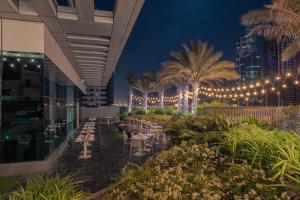 a restaurant at night with lights and palm trees at Stella Di Mare Dubai Marina Hotel in Dubai