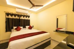 a bedroom with a large white bed with red pillows at Hotel Elite Park in Tirupati
