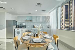 a dining room with a table and chairs in a kitchen at bnbmehomes - 54th Floor Sea View - Heart of Marina - 5407 in Dubai