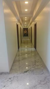 un corridoio con pavimento in marmo e un dipinto sul muro di Hotel Mayur Residency a Ellora