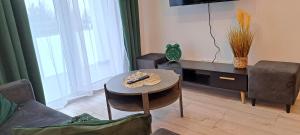 a living room with a coffee table and a tv at Apartament ROYAL in Koszalin