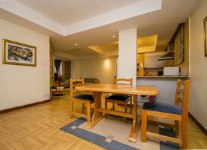 ナイロビにあるCozy Sarit Apartmentのキッチン、ダイニングルーム(木製のテーブルと椅子付)