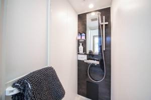 bagno con doccia, lavandino e specchio di THE NORTH PEAK 201 a Furano