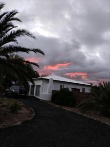 een wit huis met een auto ervoor geparkeerd bij Karoo C in Beaufort West