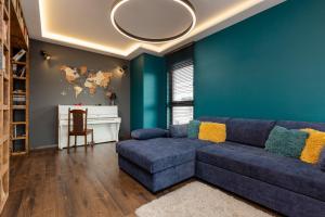 Emerald Residence Warsaw with Parking by Renters في وارسو: غرفة معيشة مع جدران زرقاء وأريكة