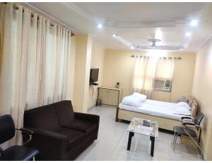 a hospital room with a bed and a couch at Hotel Gharana, Gaya in Gaya