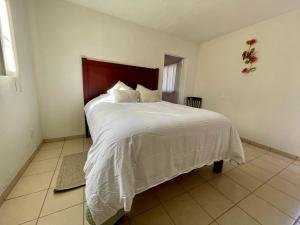 een slaapkamer met een groot bed en een wit dekbed bij Suite AMAI, Valle de Guadalupe in Colonia de Guadalupe