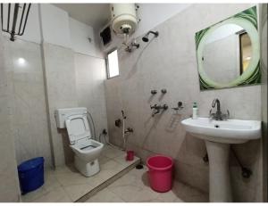 a bathroom with a sink and a toilet and a mirror at Hotel Gharana, Gaya in Gaya