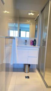 La salle de bains est pourvue d'un lavabo et d'un miroir. dans l'établissement Stylish modern 2 BR in Lawson, à Belconnen