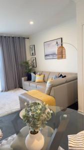 uma sala de estar com um sofá e uma mesa de vidro em Stylish modern 2 BR in Lawson em Belconnen