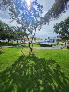 drzewo rzuca cień na trawę w parku w obiekcie Resort Oceanami Vũng Tàu w mieście Long Hai