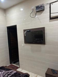 een kamer met een muur en een flatscreen-tv bij NAGPAL GUEST HOUSE in Ludhiana