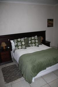 una camera da letto con un grande letto con cuscini sopra di Erf Three Seven Eight Langstrand Self-Catering a Langstrand
