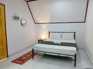 - une chambre avec un lit et une lampe sur une table dans l'établissement Zainab Cottage, à Pasir Puteh