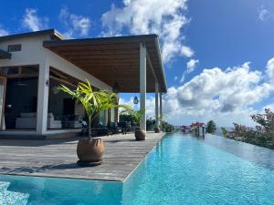 a villa with a swimming pool next to a house at Infinity Luxury Villa - Stunning Sea and Piton Views in Soufrière