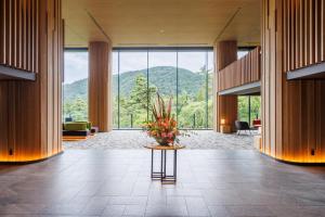 eine Lobby mit einer Vase Blumen auf dem Tisch in der Unterkunft Hakone Kowakien Hotel in Hakone