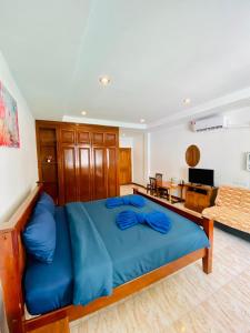 a bedroom with a blue bed and a living room at BT hotel Kata Beach in Kata Beach