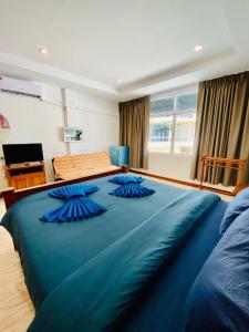 a large blue bed with blue pillows on top of it at BT hotel Kata Beach in Kata Beach