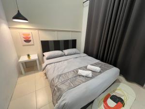 1 dormitorio con 1 cama con 2 toallas en DeMUJI 4BR 10PAX 3Min to ECM KCM, PS4, en Kuantan