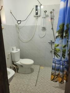 ein Bad mit einem WC und einem Duschvorhang in der Unterkunft Villa sea spray in Hikkaduwa