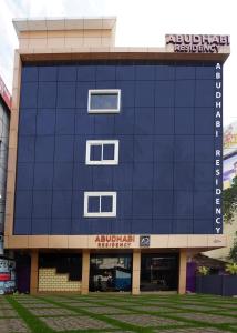 un gran edificio azul con un cartel. en ABUDHABI RESIDENCY, en Palakkad