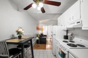 a white kitchen with a table and a ceiling fan at Stylish 1br Unit Bella Vista By Center City in Philadelphia