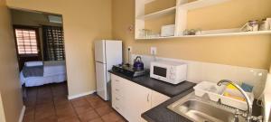 uma pequena cozinha com um lavatório e um frigorífico em Hexberg Cottage em Wellington