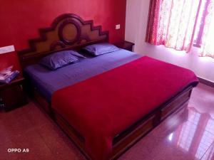 a red bedroom with a large bed with a red blanket at Rexon Residency in Kattappana