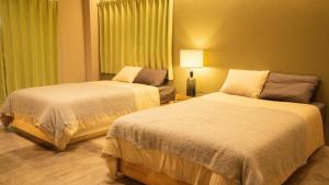 une chambre d'hôtel avec deux lits et une lampe dans l'établissement Hotel Re:Plug, à Kōchi