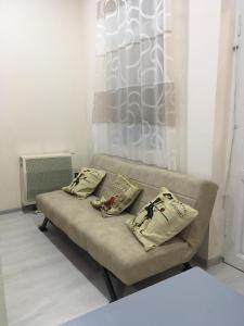 um sofá numa sala de estar com almofadas em Guesthouse em Oni