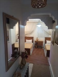 a bedroom with two beds and a large mirror at Appt, Agréable Lumineux et ensoleillé in Agadir