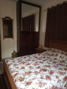 a bedroom with a bed with a floral comforter at Appt, Agréable Lumineux et ensoleillé in Agadir