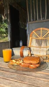 Lotus Jewel Forest Camping في سلطان بتيري: طبق من السندويشات على طاولة مع كوب من عصير البرتقال