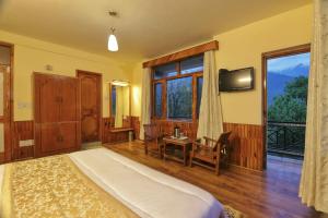 a bedroom with a bed and a tv and a desk at Grey Moustache 4BHK in Manāli