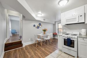 una cocina con electrodomésticos blancos y una mesa con sillas. en Beautiful 2bdrm Large Flat Univ City en Filadelfia