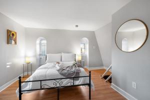 a bedroom with a bed and a large mirror at Beautiful 2bdrm Large Flat Univ City in Philadelphia