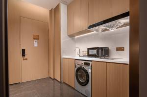 a kitchen with a washing machine and a microwave at Grand Mercure Chengdu East in Chengdu