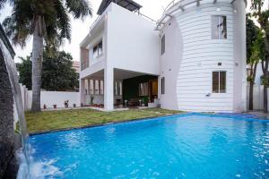 a house with a swimming pool in front of a house at Ishara villa in Indore