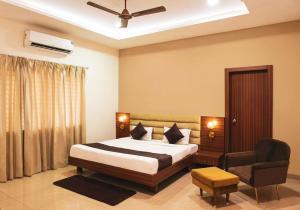 a bedroom with a bed and a chair at Ishara villa in Indore